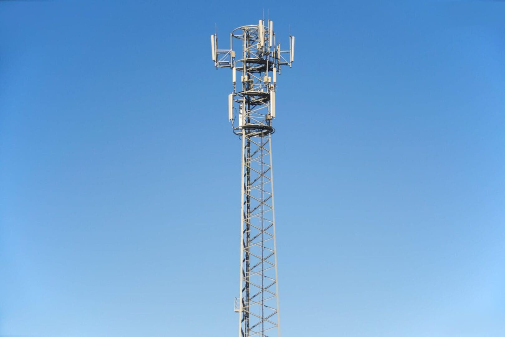 A tall communication tower against a clear blue sky.